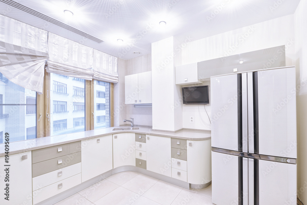 Modern design white kitchen in a spacious apartment. Modern design white kitchen in a spacious apartment.