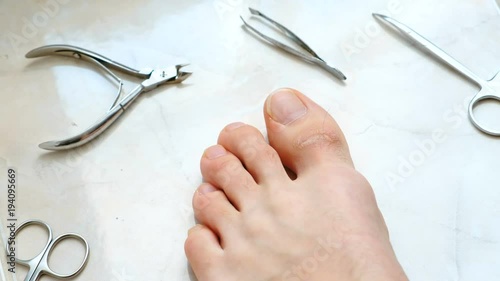 Man cutting toenails with clipper. Male cut toenails on foot. Foot and toes close-up. Top view. photo