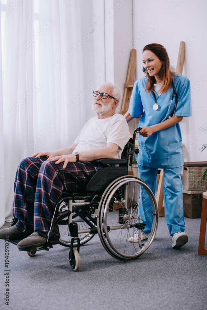 Nurse pushing wheelchair with senior patient Nurse pushing wheelchair with senior patient