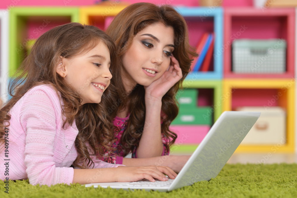 woman and little girl using laptop woman and little girl using laptop