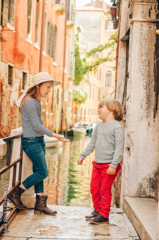 Two kids playing on the bridge in Venice. Little girl and boy visiting Venice, Italy. Small tourists in Europe