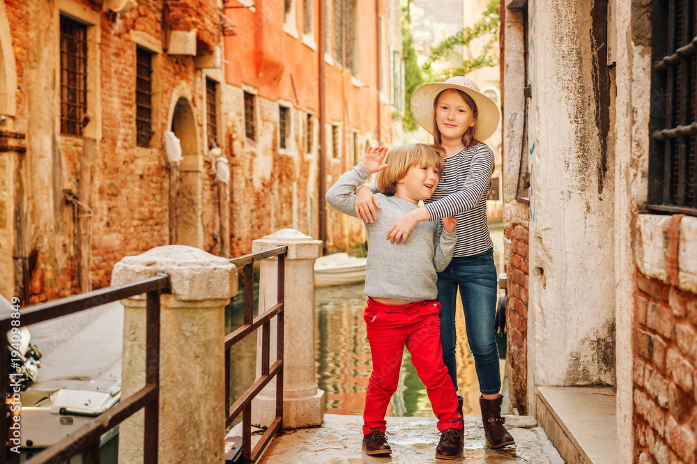 Two kids playing on the bridge in Venice. Little girl and boy visiting Venice, Italy. Small tourists in Europe Two kids playing on the bridge in Venice. Little girl and boy visiting Venice, Italy. Small tourists in Europe