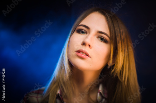 portrait smiling girl on blue background in studio