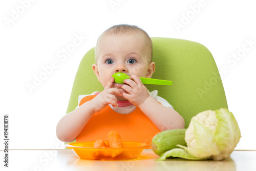 Baby holding spoon with fre...