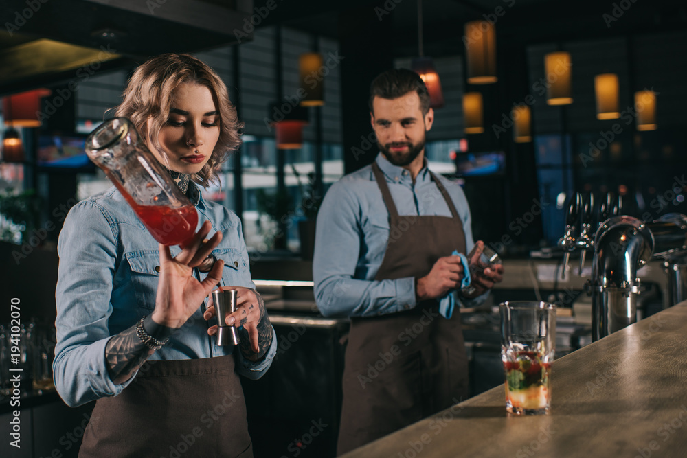 female and male bartenders working at bar