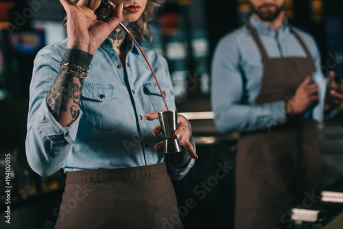 cropped image of bartender preparing drink at bar