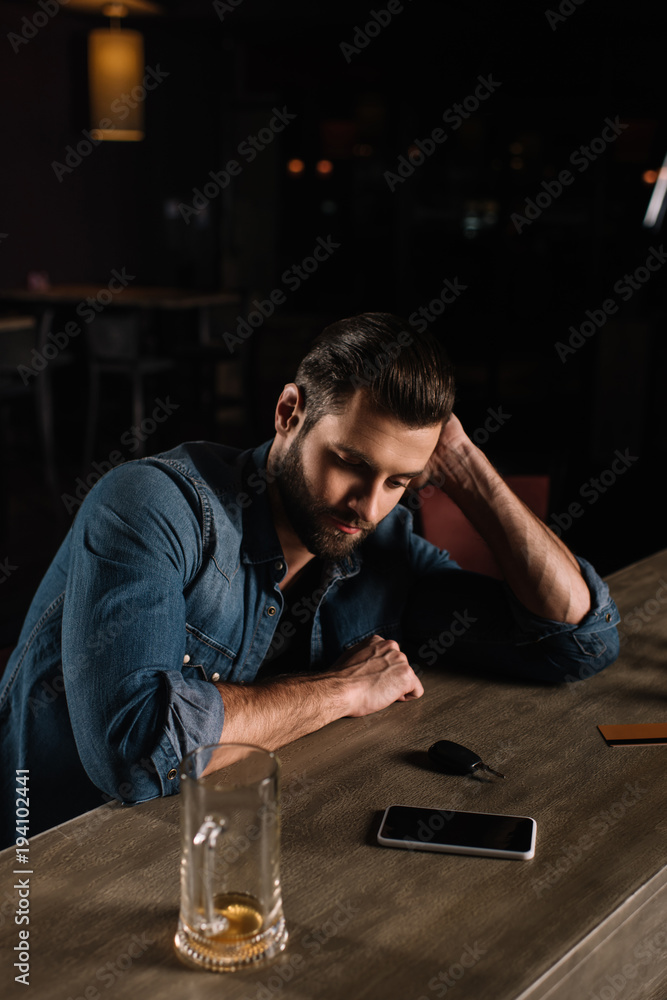 Obraz premium tired visitor sitting at bar counter in evening