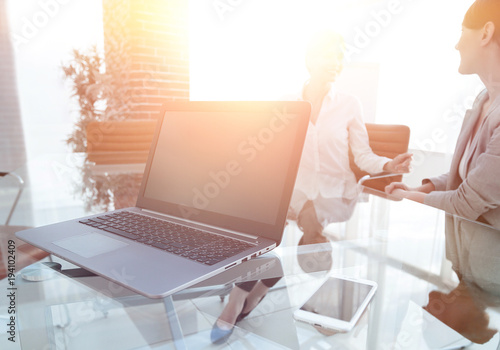 laptop and a smartphone on the desktop of a businessman