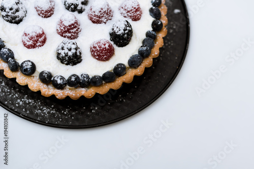 top view of cake with berries and sugar powder