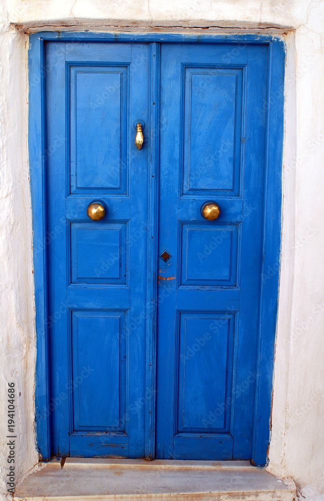Traditional wooden door in blue color, Isternia village, Tinos island, Cyclades, Greece.