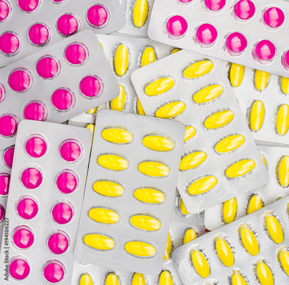 Top view of pink and yellow tablets pill in blister packs. NSAIDs can irritated stomach cause gastric ulcer. Pills for relief pain, period cramps, headache and toothache.