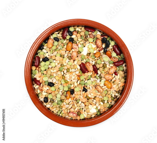 Mixed dried legumes and cereals in clay bowl isolated on white background