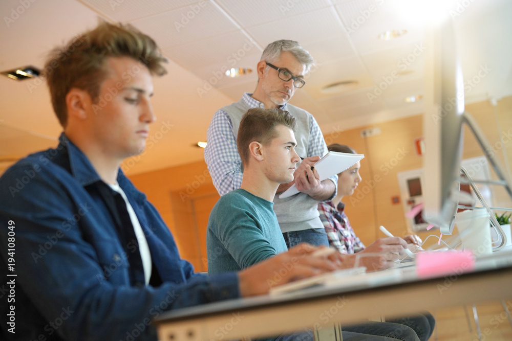 Obraz premium Group of students in computing class with teacher