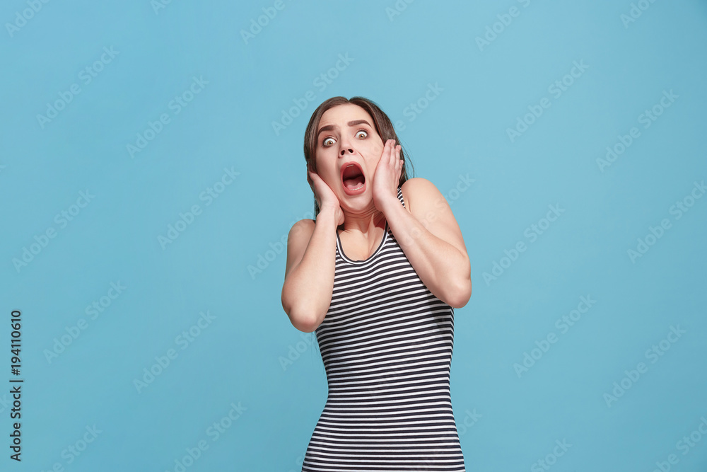 Fototapeta premium Portrait of the scared woman on blue