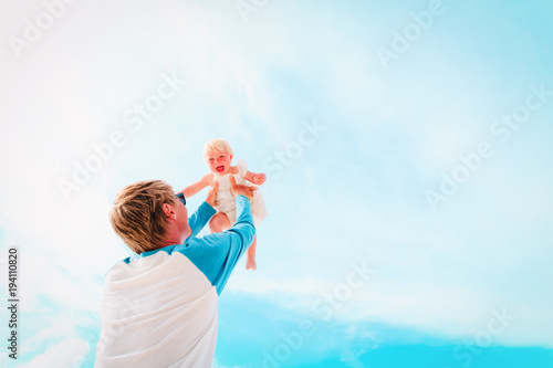 father and happy little daughter play at sky