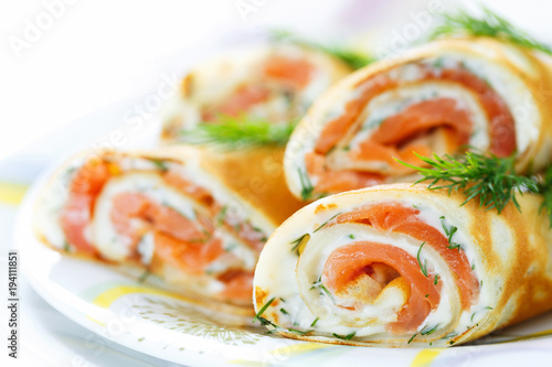 Pancakes with fish salmon, cheese and dill. Macro. Space for text