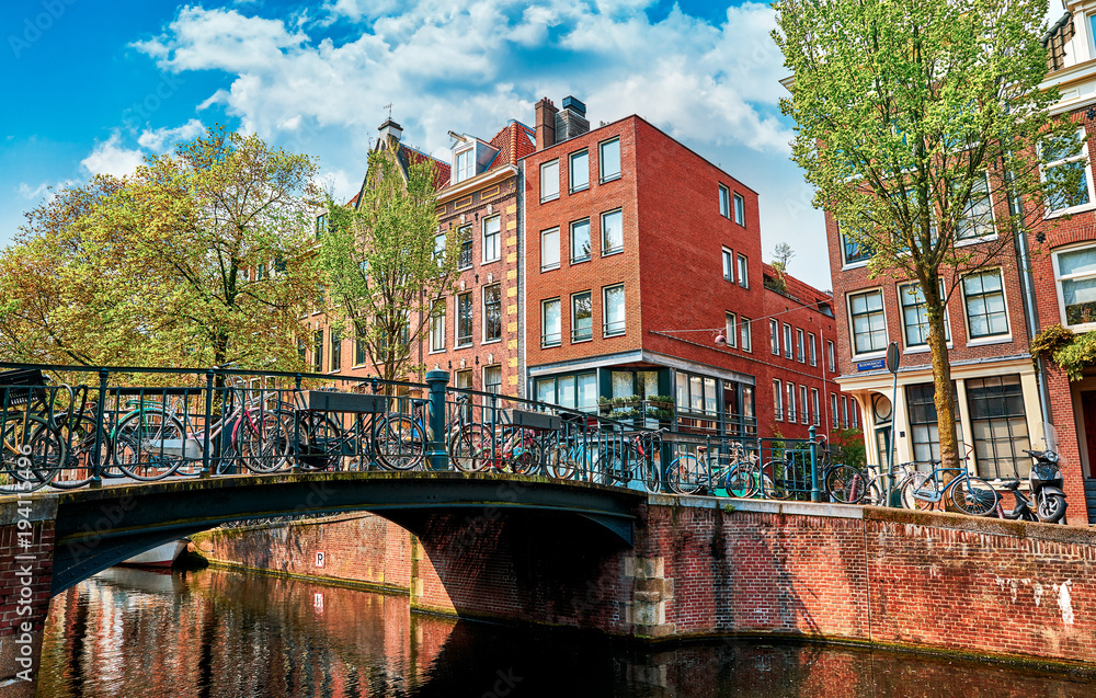Naklejka premium Bridge over channel in Amsterdam Netherlands houses river Amstel