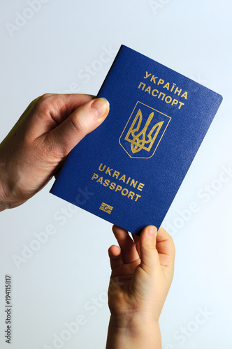 Blue Ukrainian passport in the hands of the child and the woman. Isolate