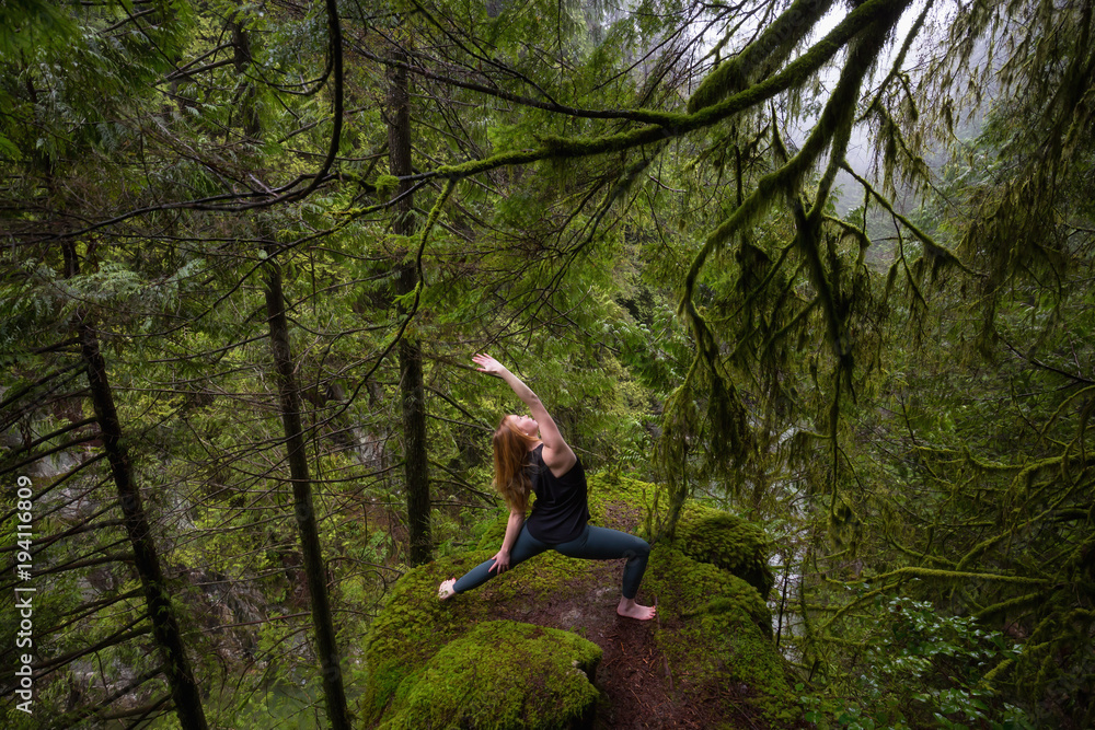 Young Caucasian Girl is practicing yoga in the rain forest. Taken in Capilano Canyon, North Vancouver, BC, Canada. Young Caucasian Girl is practicing yoga in the rain forest. Taken in Capilano Canyon, North Vancouver, BC, Canada.
