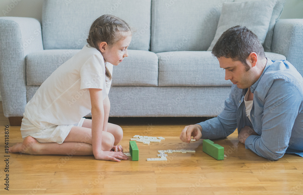 Father and daughter playing dominoes at home. Father and daughter playing dominoes at home.