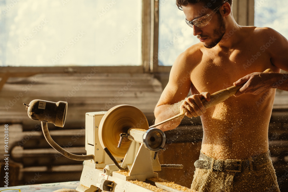 wood lathe, lathe naked operator working a wood pestle Stock Photo