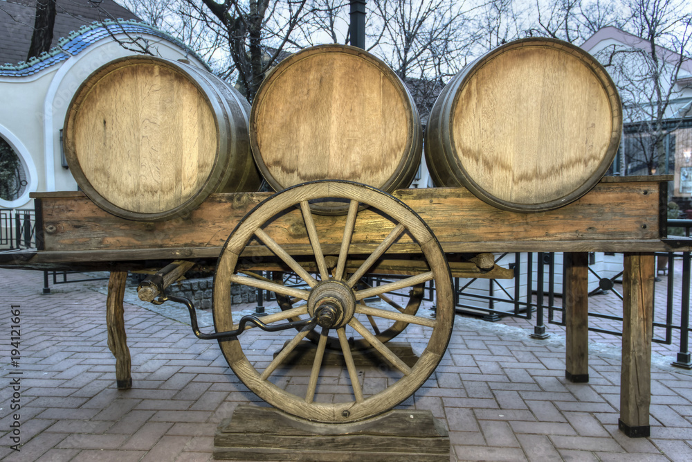 Wine barrels on a cart in a paved courtyard