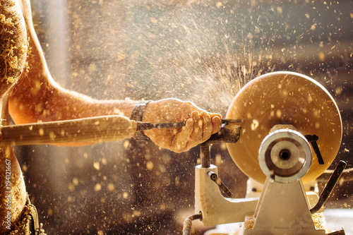 Fotografie Wood lathe .The naked Carpenter lathing wood to make product