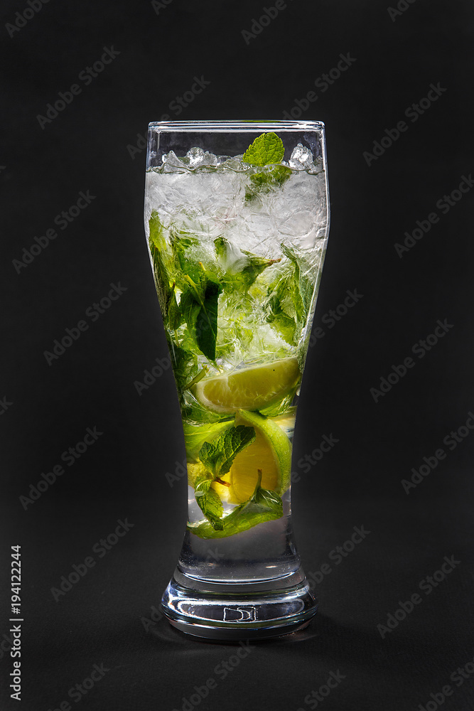 Summer drink with lime and mint, ice on isolated black background. Direct perspective, cool, refreshing Summer drink with lime and mint, ice on isolated black background. Direct perspective, cool, refreshing