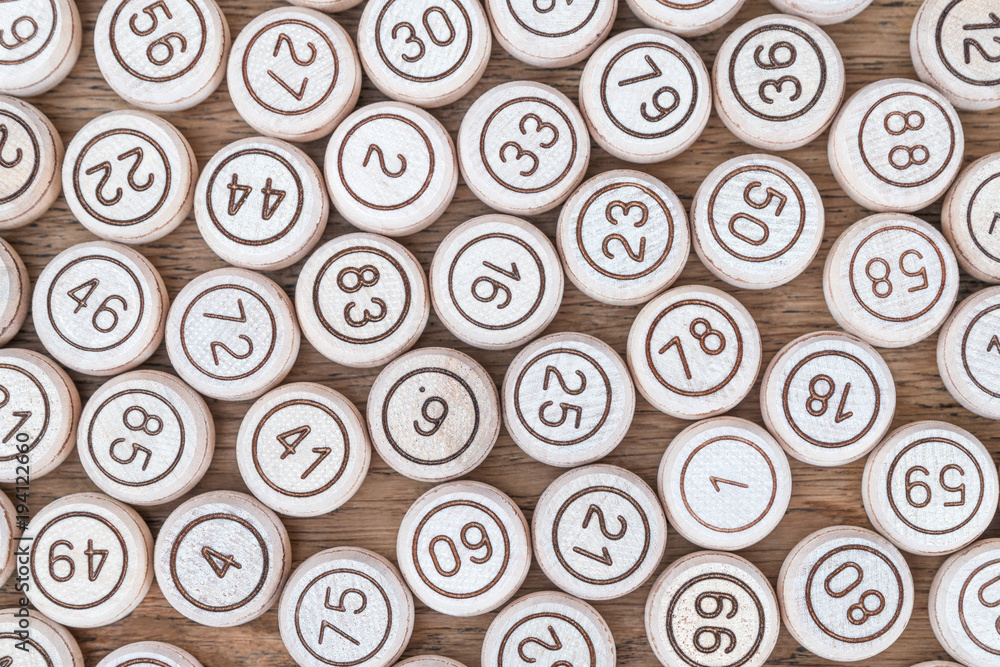 Group of kegs from a lotto game standing one next to the other on a wooden table Group of kegs from a lotto game standing one next to the other on a wooden table