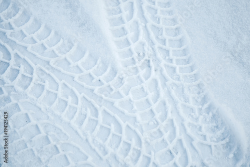 Tire tracks pattern on winter road with snow photo