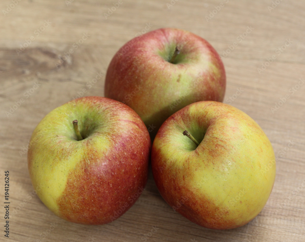 Red and yellow fresh braeburn apples on wooden background