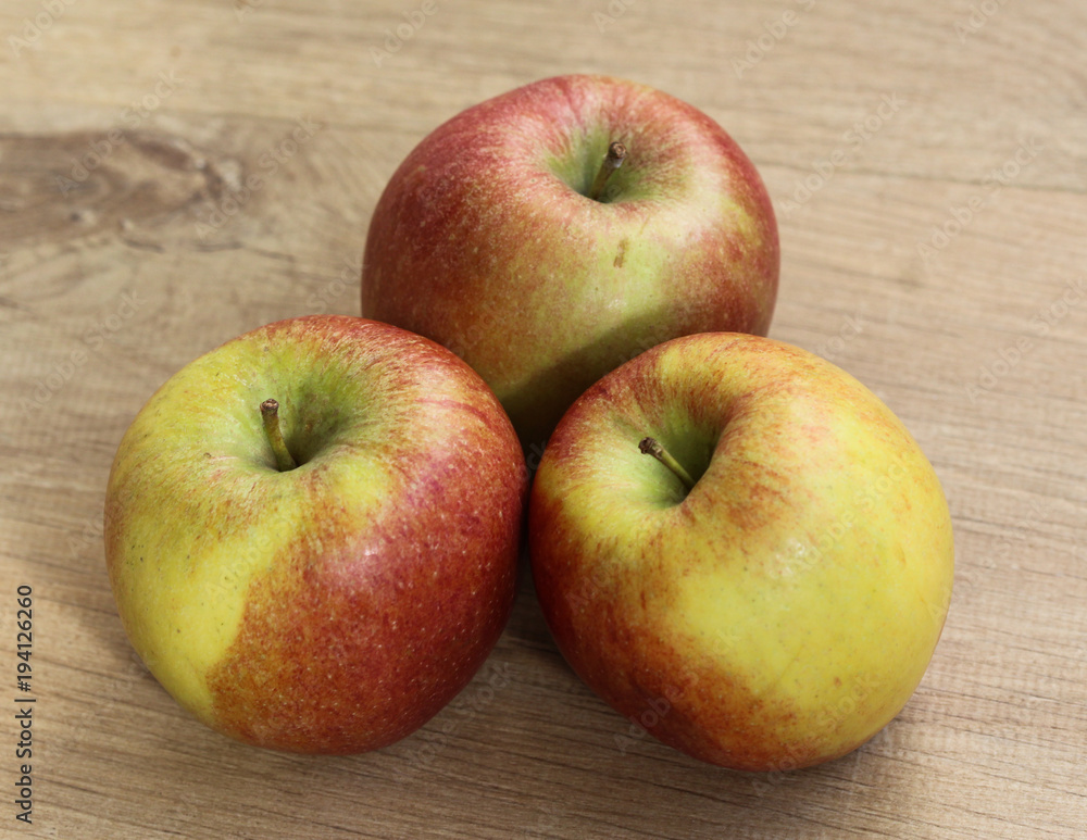 Red and yellow fresh braeburn apples on wooden background Red and yellow fresh braeburn apples on wooden background