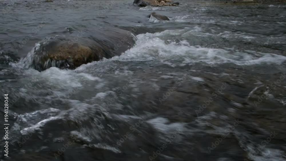 Close up.Pure fresh water waterfall in forest with black rocks. 