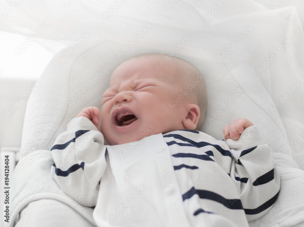 Newborn baby tears while lying in bed