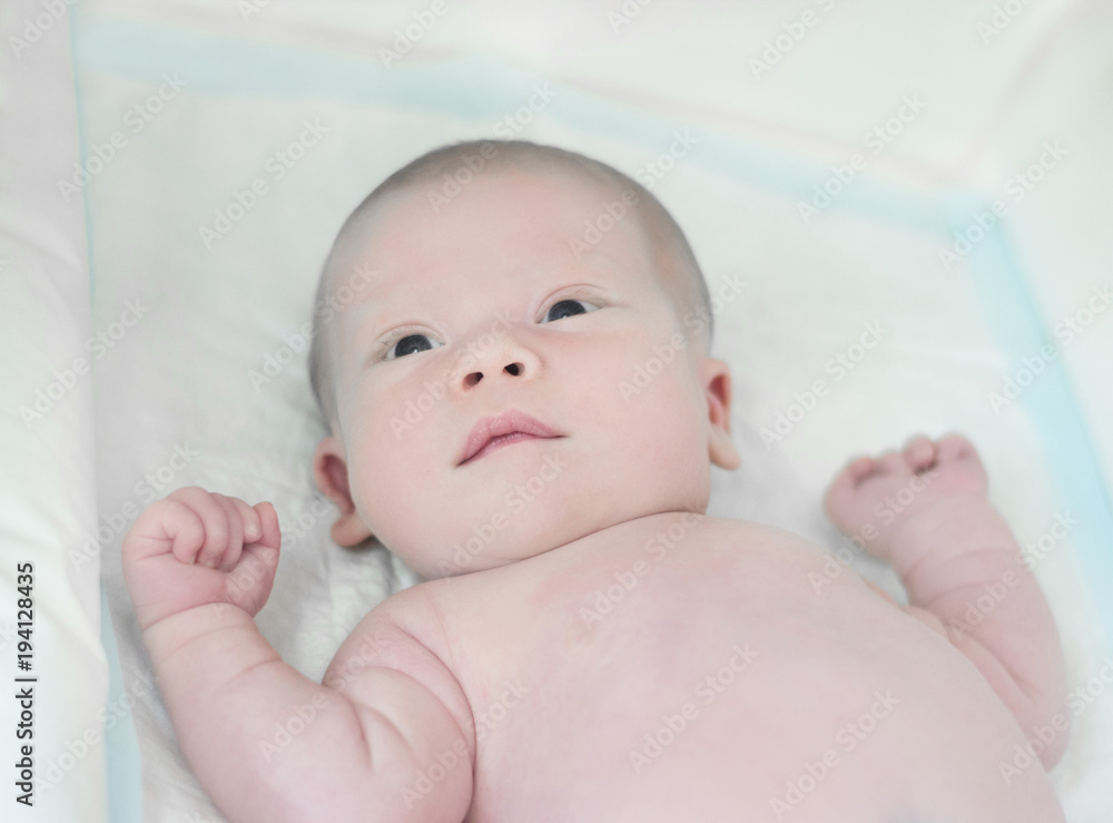 Newborn baby boy lying in bed without clothes Newborn baby boy lying in bed without clothes