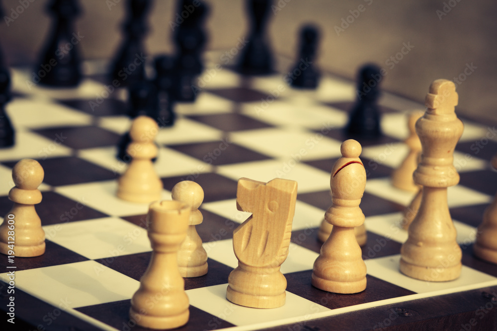 Close up white and black wooden chess pieces on board Close up white and black wooden chess pieces on board