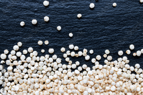 Quinoa seeds on black slate background, macro, top view