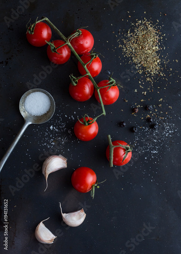 Tomaten mit Knoblauch, Salz und Pfeffer mit einem dunklen Hintergrund
