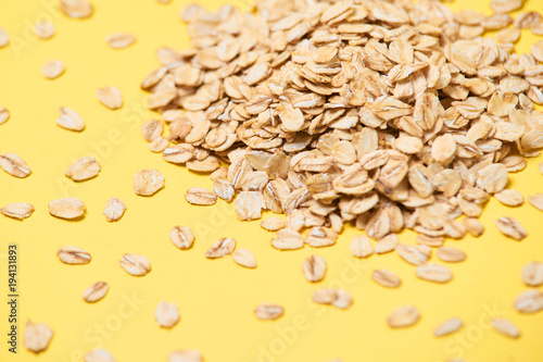 Many of oat flakes. Healthy eating. Yellow background