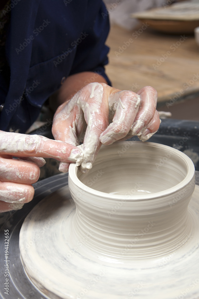 A lady ceramics artist at work in her home pottery studio.