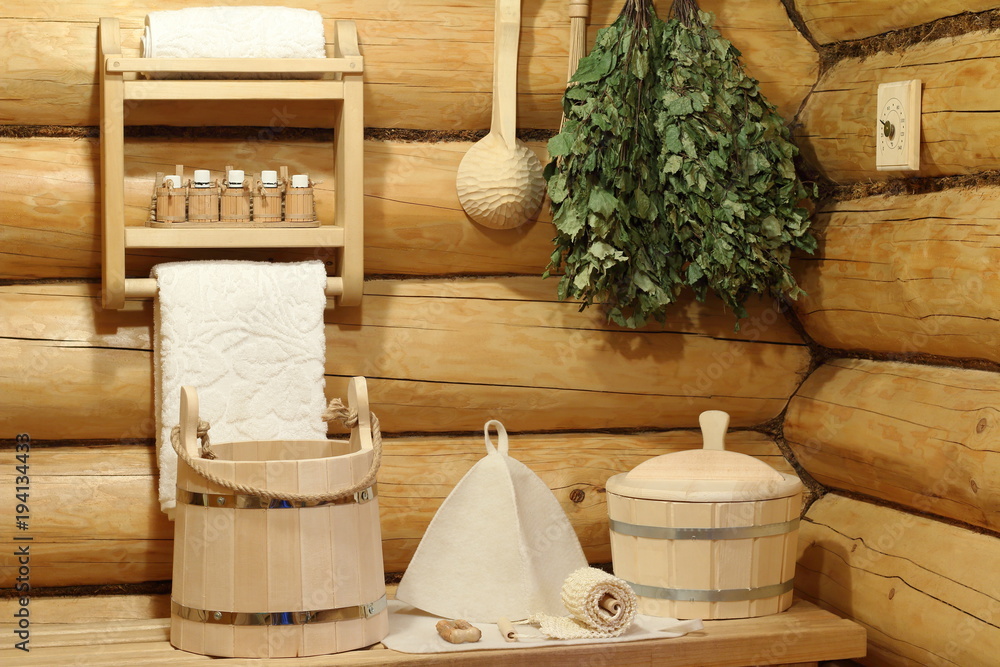 Obraz premium Part of the interior of the Russian bath and bath accessories. Bath accessories on the background of the log walls of the Russian bath.