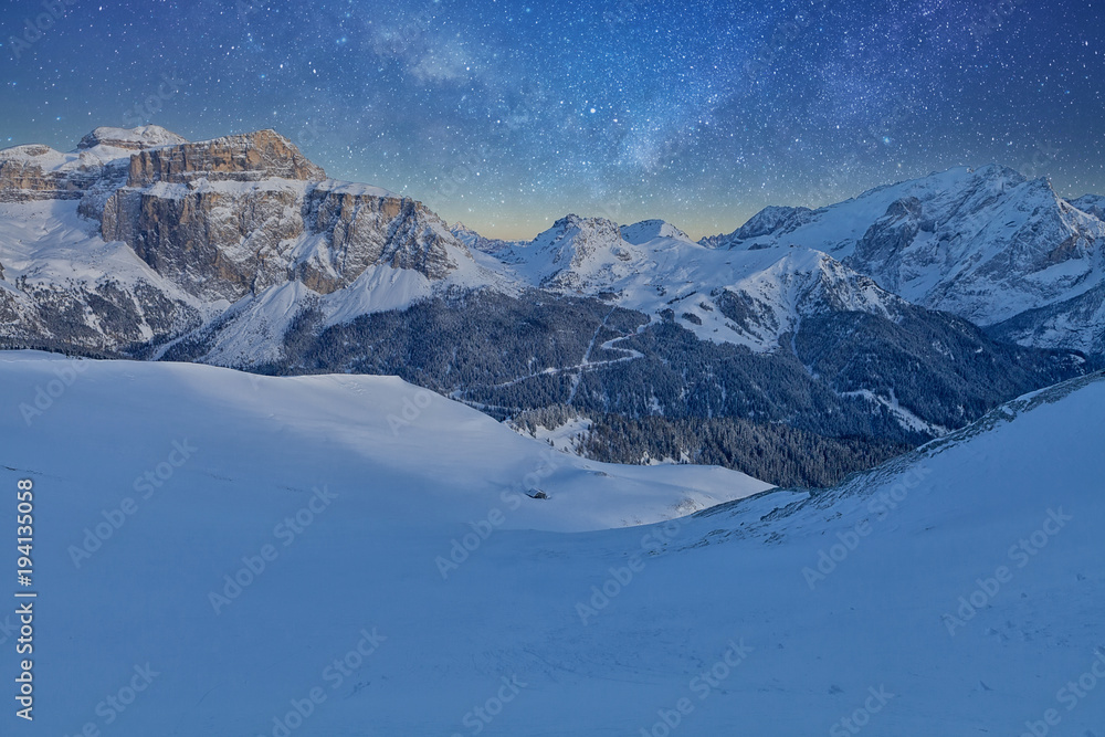 Fantastic starry sky. Panoramic view of the Val Di Fassa ski resort of the Italian Dolomites under starry light Fantastic starry sky. Panoramic view of the Val Di Fassa ski resort of the Italian Dolomites under starry light