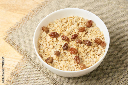 Delicious healthy breakfast. Neutral background. Oatmeal with raisins