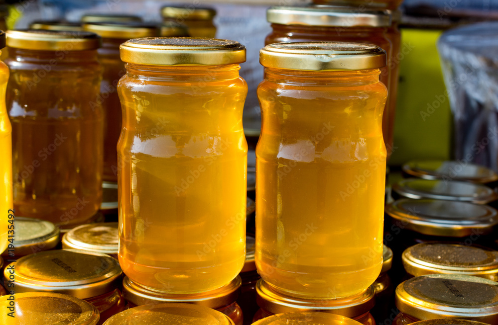 Glass jar of honey set with lid closeup Glass jar of honey set with lid closeup