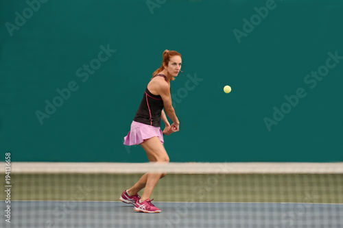 femme jouant au tennis dans un gymnase