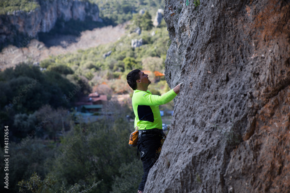 the rock-climber climbs in top a difficult route
