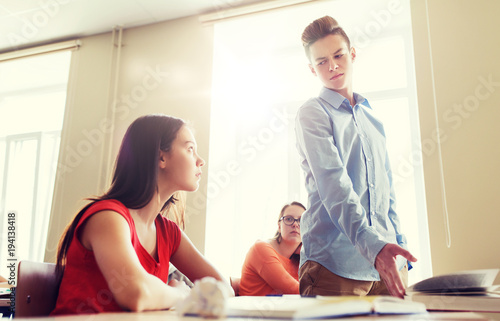 students gossiping behind classmate back at school