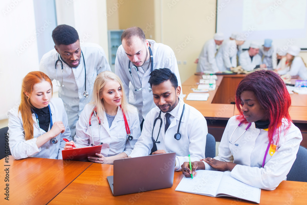 healthcare. A group mixedrace of student medical students communicates in front of a laptop. Discussion of the diagnosis