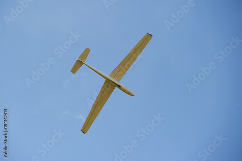 A Glider flying in bleu sky. The glider is a plane that has no engine
