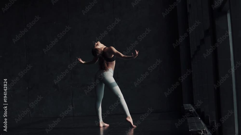 flexible girl is warming up. young woman in sportswear doing yoga. back view flexible girl is warming up. young woman in sportswear doing yoga. back view
